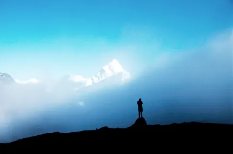 Manfred Häupl steht als kleine Silhouette im Schatten des Bergs Awa Dablam