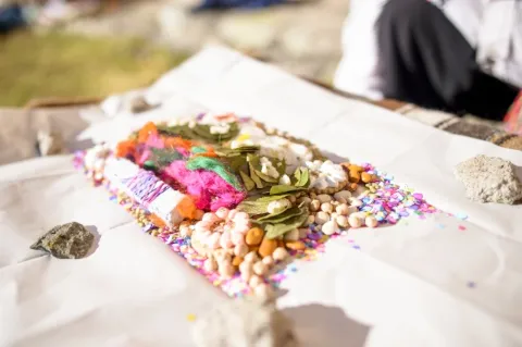 Auf einem Silbertablett liegen verschiedene, bunte Lebensmittel. Die Platte steht auf einem weißen Tisch in der Natur.
