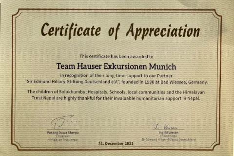 Eine braune Urkunde mit dem Titel "Certificate of Appreciation" ist zu sehen. Auf der Urkunde wird die Firma Hauser Exkursionen für die langjährige Unterstützung der Sir Edmund Hillary Stiftung geehrt.