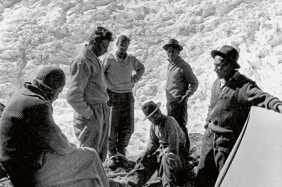 Eine Gruppe von Bergsteigern steht im Kreis und bespricht sich