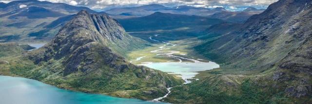 Blick auf grüne Berglandschaft mit kleinen Seen in den Tälern. 