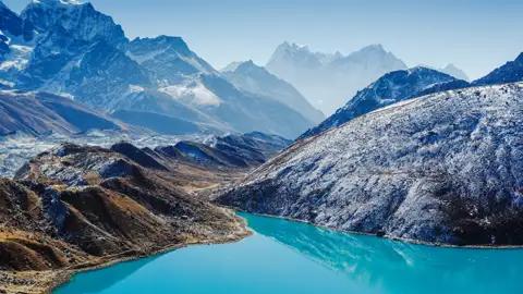 Türkisfarbener See und schneebedeckte Berge.