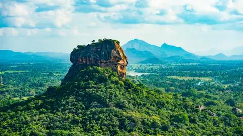 Der majestätische Sigiriya Felsen, eine alte Felsenfestung in Sri Lanka, erhebt sich über dem umliegenden Dschungel.