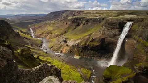 Spektakulärer Wasserfall, der in eine felsige Schlucht stürzt und von einem Fluss durchflossen wird.