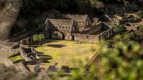 Überreste von Gebäuden und Mauern einer historischen Stätte, möglicherweise Teil einer archäologischen Ausgrabung.