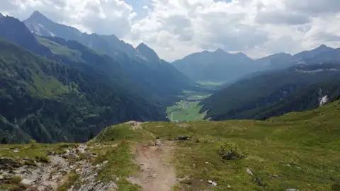 Wanderweg mit Heidelandschaft und Alpenpanorama