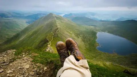 Aussicht vom Gipfel auf einen Bergsee und die umliegende Berglandschaft.