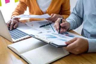 Besprechung zwischen Arbeitskollegen im Büro vor dem Laptop