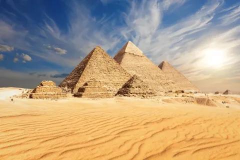 Große Pyramiden in der Wüste unter blauem Himmel.