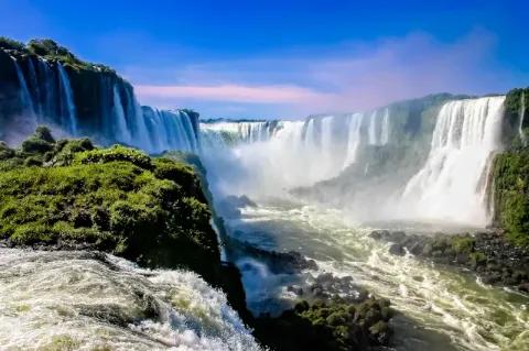 Blick auf die Iguazu Wasserfälle. Der Himmel ist strahlend blau.