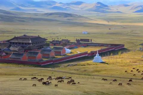 Blick auf eine rot umrandete Siedlung mit roten Zelten inmitten einer grünbraunen Steppenlandschaft.