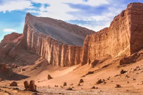 Hohe Felsen in einer Wüstenlandschaft bei bewölktem Himmel