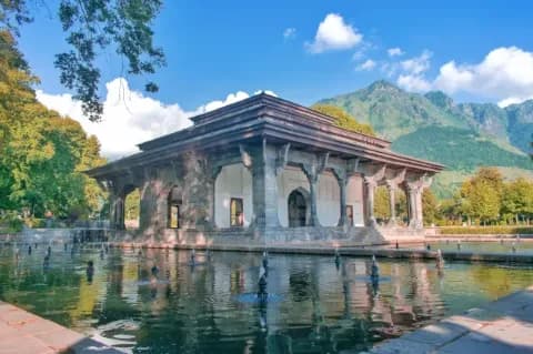 Blick auf einen Tempel der auf dem Wasser liegt. Im Hintergrund sind Berge zu sehen.