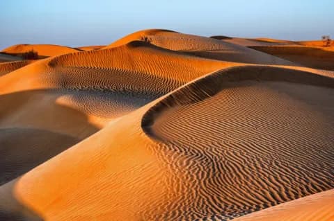 Weite Dünenlandschaft in der Wüste bei Sonnenuntergangsstimmung