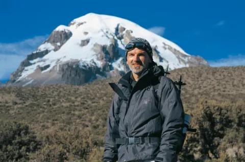 Manfred Häupl steht im Wanderoutfit vor einem Berg