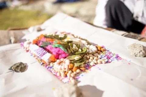 Auf einem Silbertablett liegen verschiedene, bunte Lebensmittel. Die Platte steht auf einem weißen Tisch in der Natur.
