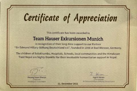 Eine braune Urkunde mit dem Titel "Certificate of Appreciation" ist zu sehen. Auf der Urkunde wird die Firma Hauser Exkursionen für die langjährige Unterstützung der Sir Edmund Hillary Stiftung geehrt.