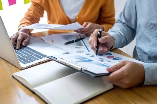 Besprechung zwischen Arbeitskollegen im Büro vor dem Laptop