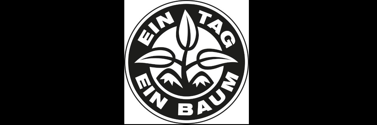 Ein schwarzer Kreis auf weißem Hintergrund. In dem Kreis steht "Ein Tag ein Baum". In der Mitte ist eine kleine Pflanze mit drei Blätter abgebildet.