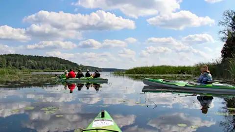 Kajaks auf einem See mit Wolkenreflexion.