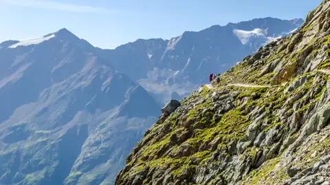 Wanderer auf einem Bergpfad in den Alpen.