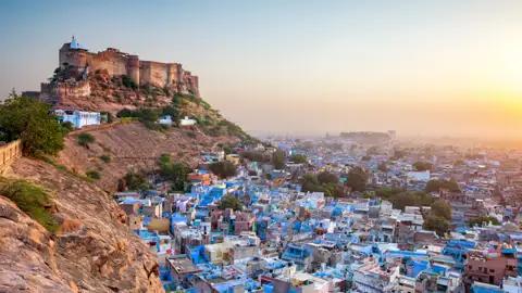 Panorama von Jodhpur mit den blauen Häusern und dem Mehrangarh Fort bei Sonnenaufgang.