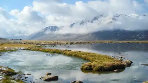 Bergsee mit Wolkenverhangenen Gipfeln