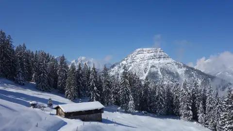 Verschneite Hütte in den Bergen im Winter.