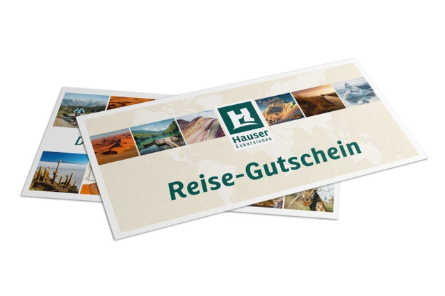 Eine Reisegutschein der Firma Hauser Exkursionen liegt auf weißem Untergrund
