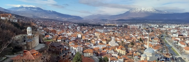 Ausblick über die Stadt mit vielen Häusern und teilweise weißer Bergkette im Hintergrund 