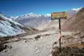 Wegweiser mit den Ortsangaben Muktinath und Chhyonkhar auf einer Trekkingroute im Himalaya.