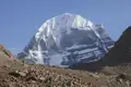 Der schneebedeckte Gipfel des heiligen Berges Kailash, umgeben von einem felsigen Gelände.