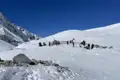 Wanderer pausieren in einer verschneiten Berglandschaft während ihrer Reise.