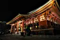 Beleuchteter japanischer Tempel bei Nacht.
