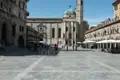 Blick auf die Piazza del Comune mit Besuchern und umliegenden Gebäuden.