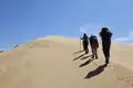Wanderer besteigen eine Sanddüne während ihrer Reise.