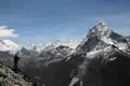 Panoramablick auf die schneebedeckten Gipfel des Himalaya mit einem Wanderer im Vordergrund.