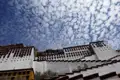 Der Potala-Palast, ein historisches Wahrzeichen in Tibet, unter einem beeindruckenden Wolkenhimmel.