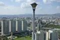 Ausblick über die Stadt mit modernen Wohngebäuden und einer goldenen Statue, möglicherweise ein religiöses Denkmal.