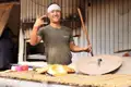 Bäcker präsentiert Fladenbrot an seinem Stand.