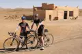 Zwei Radfahrer pausieren während ihrer Radtour in der Wüste vor einem Café.