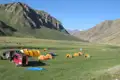 Reise-Basislager mit Zelten und Fahrzeugen im Tal.