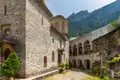 Steingebäude und Innenhof eines Klosters mit Bergkulisse.