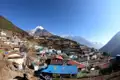 Panoramablick auf ein Bergdorf im Himalaya mit Blick auf die schneebedeckten Gipfel.