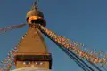 Nahaufnahme des Boudhanath Stupa mit seinen charakteristischen Augen und den umliegenden Gebetsfahnen.