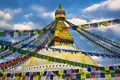 Der Boudhanath Stupa mit seinen charakteristischen Augen und den umgebenden Gebetsfahnen.