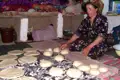 Frau beim Zubereiten von Fladenbroten, eine traditionelle Tätigkeit.