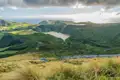 Aussicht auf einen vulkanischen Kratersee auf den Azoren, umgeben von üppiger Vegetation.