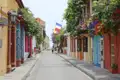 Farbenfrohe Häuserfassaden und blühende Pflanzen entlang einer Straße in Cartagena.