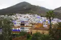 Blaue Häuser von Chefchaouen mit Bergen im Hintergrund.